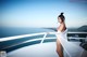 A woman in a white dress standing on a balcony.