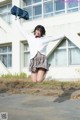 A woman in a school uniform jumping in the air.