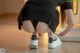 A woman in a black dress and white sneakers crouching on the floor.