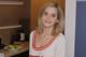 A woman in a white shirt standing in a kitchen.