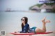 A woman laying on a surfboard on the beach.