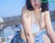 A woman in a white bra sitting on a boat.