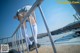 A woman in a skirt and stockings leaning against a railing.