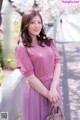 a woman in a pink dress holding a handbag