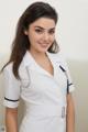 A woman in a white nurse uniform posing for a picture.