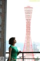 A woman standing in front of a tall tower.